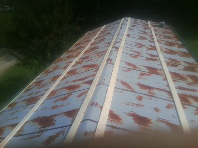 Rusted metal roof panels with new wood purlins before replacement — Storm Damage Roof Repair in Santa Claus by Roofing Brothers