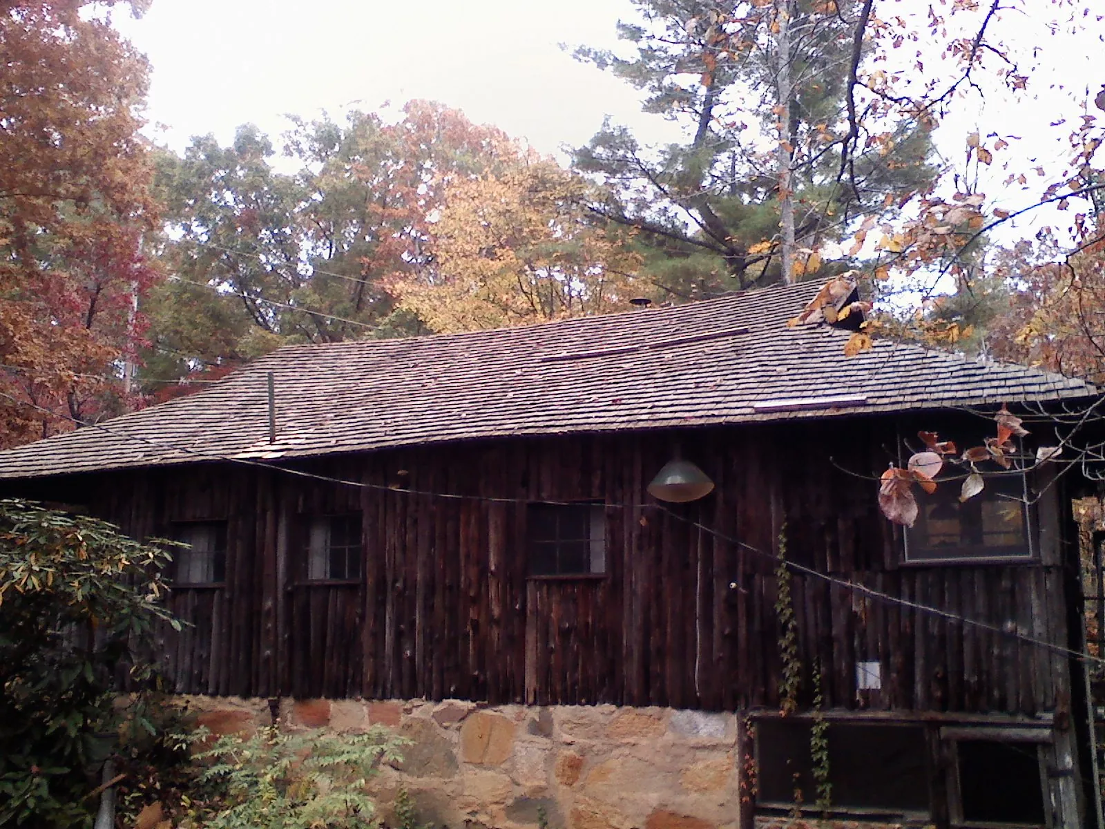 Weathered wood shake roof on a rustic board sided cabin in Santa Claus